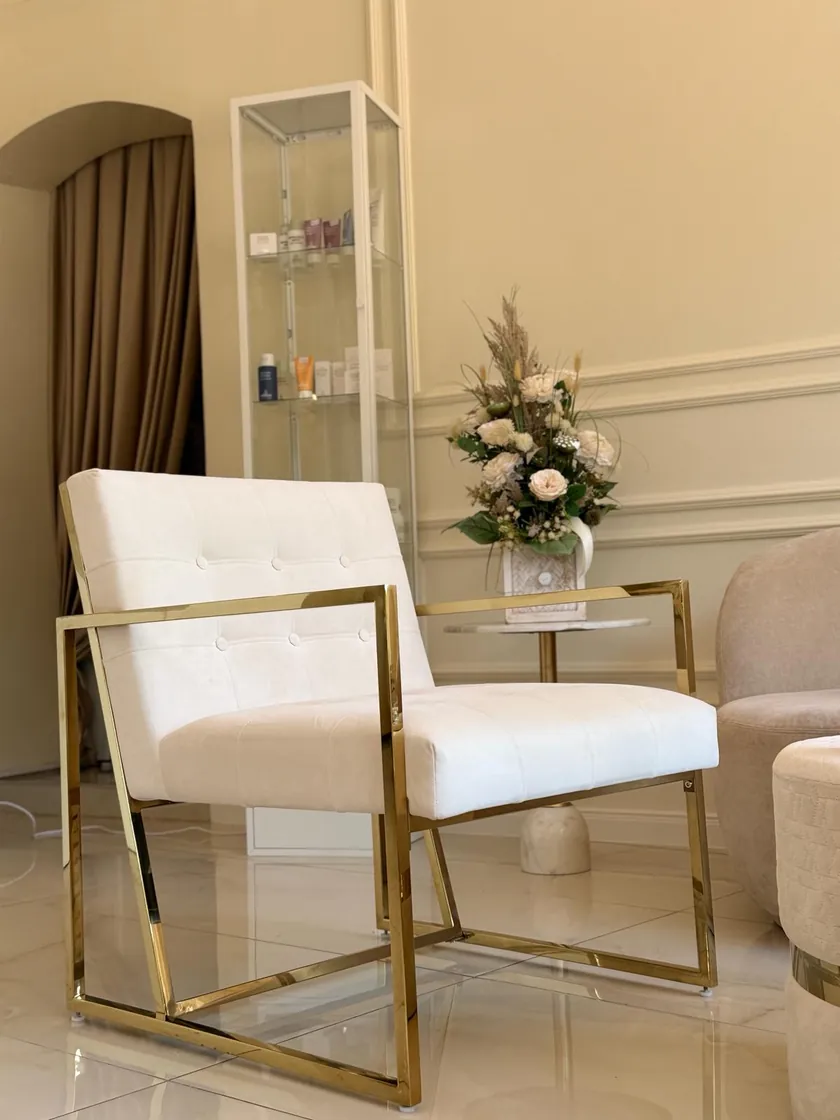 Sitzecke im Wartebereich — Sessel mit goldenem Gestell und Blumen