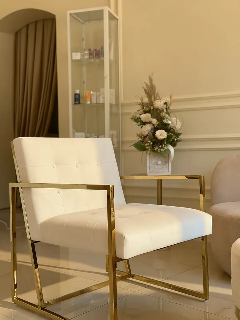 Sitzecke im Wartebereich — Sessel mit goldenem Gestell und Blumen